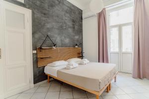 Schlafzimmer mit einem Bett mit einem Kopfteil aus Holz in der Unterkunft Valentine's Dream in Rom