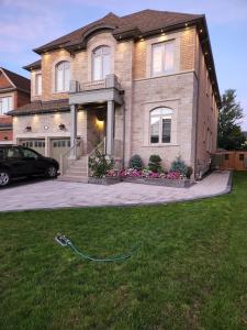 a house with a green hose in the grass at 2 Bedrooms 2 washrooms 2 parking spots Basement Apartment in Newmarket