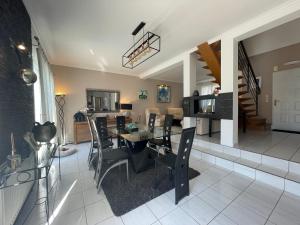 a dining room and living room with a table and chairs at La Maison Sarthoise - 24H Du Mans - 4 pers in Saint-Saturnin