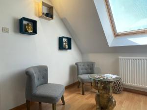 a room with two chairs and a table and a skylight at La Maison Sarthoise - 24H Du Mans - 4 pers in Saint-Saturnin