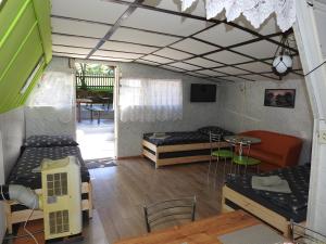 a room with two beds and a table and chairs at Ubytovanie u Krokodíla in Banská Belá