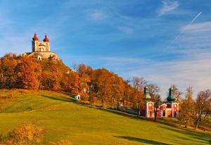a castle on top of a hill with a green field at Ubytovanie u Krokodíla in Banská Belá