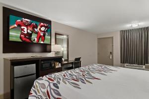 a hotel room with a bed and a flat screen tv at Red Roof Inn Baldwin in Baldwin