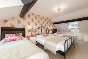 1 dormitorio con 2 camas y ventana en The Tall House - Sleeps 16, en Keswick