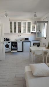 cocina con armarios blancos, mesa y sillas en T2 Vue sur la Basilique de Notre Dame de la Garde, en Marsella