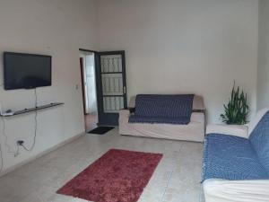 sala de estar con sofá y TV de pantalla plana en Pousada Alvinópolis en Atibaia