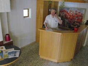 a woman standing at a counter talking on a cell phone at Hotel Stadt Mainz in Schwabenheim