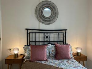 1 dormitorio con cama con almohadas rosas y espejo en DREAM BEJIA, en La Laguna