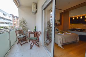 a room with a balcony with a bed and a table at NEW Spacious luxury studio in elite neighborhood in Novi Sad