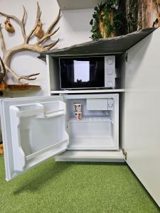 een open koelkast met een magnetron bovenop bij ROVIO REST IN FOREST in Jyväskylä