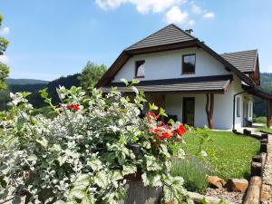 uma casa com flores em frente em CHATA NA KOŃCU ŚWIATA em Wetlina