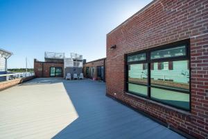 a brick building with a deck with two chairs on it at Why Knot Getaway…Rooftop with WaterView! Unit F in Beaufort