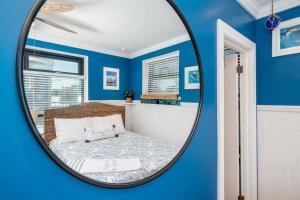 a mirror in a blue room with a bed at Why Knot Getaway…Rooftop with WaterView! Unit F in Beaufort