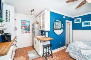 a kitchen with blue walls and a bed in a room at Why Knot Getaway…Rooftop with WaterView! Unit F in Beaufort