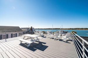 a deck with a picnic table and chairs on the water at Why Knot Getaway…Rooftop with WaterView! Unit F in Beaufort
