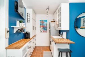 a kitchen with blue walls and white cabinets at Why Knot Getaway…Rooftop with WaterView! Unit F in Beaufort