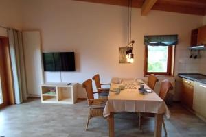 cocina con mesa y sillas y TV en Ferienwohnung Seebaer, en Ramsberg