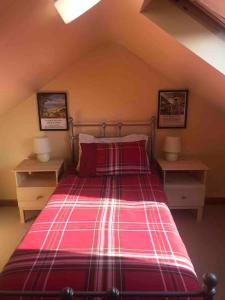 um quarto com uma cama com lençóis cor-de-rosa e duas mesas de cabeceira em Downshire Cottage: Cosy home in Holywood Centre em Holywood