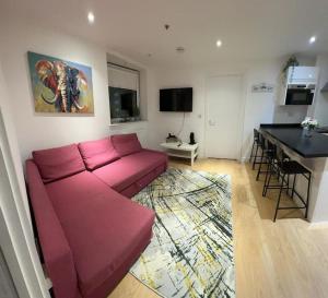 sala de estar con sofá rosa y mesa en Comfortable 2 BR Flat TH542 en Basildon