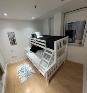 Litera blanca en habitación con ventana en Comfortable 2 BR Flat TH542 en Basildon