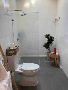 uma casa de banho branca com um WC e um chuveiro em Villa Salamanca em Dalung
