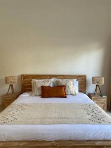 um quarto com uma grande cama branca e 2 candeeiros em Villa Salamanca em Dalung