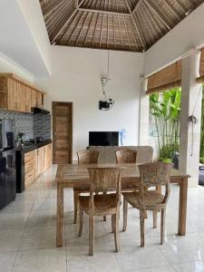 uma cozinha com uma mesa de jantar em madeira e cadeiras em Villa Salamanca em Dalung