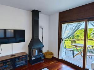 uma sala de estar com um fogão a lenha e uma mesa em L'Oasi de Molló em Molló