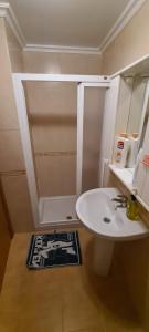 a bathroom with a white sink and a shower at Tu dulce hogar, apartamento completo,céntrico con wifi y parking gratuito in Vigo