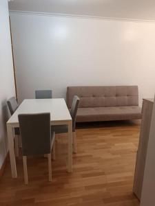 a dining room with a table and chairs and a couch at Tu dulce hogar, apartamento completo,céntrico con wifi y parking gratuito in Vigo