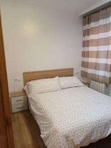 1 dormitorio con 1 cama con cabecero de madera en Tu dulce hogar, apartamento completo,céntrico con wifi y parking gratuito, en Vigo