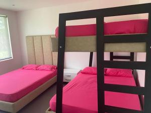 1 dormitorio con 2 literas con sábanas rosas en Bellavista, en Jamundí
