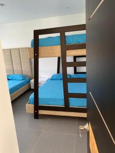 1 dormitorio con 2 literas con sábanas azules en Bellavista, en Jamundí