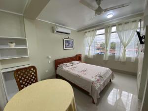 a bedroom with a bed and a table and a window at A&A HOTEL in Iquitos