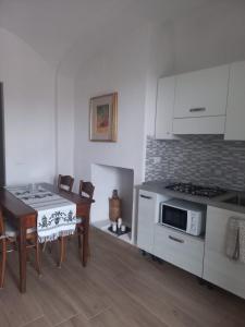 una cucina con un tavolo e una stufa forno superiore di I Due Camini a Baraggia di Boca