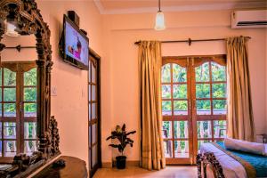 a bedroom with a bed and a large window at Casa Eternal Boutique Hotel - Calangute in Calangute