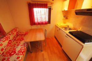 eine kleine Küche mit einem Tisch und einer Arbeitsplatte in der Unterkunft Camping & Village Rais Gerbi in Pollina