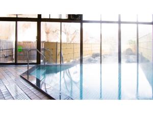 a swimming pool in a building with windows at Ashinomaki Prince Hotel - Vacation STAY 55330v in Aizuwakamatsu