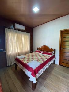 1 dormitorio con 1 cama con manta roja y blanca en Pousada Mãe Dita 