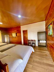 a bedroom with two beds and a table in it at Pousada Mãe Dita 