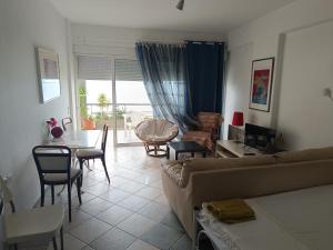 a living room with a couch and a table and chairs at Mare e Monti1 in Kamena Vourla