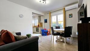een woonkamer met een bank en een tafel en stoelen bij Apartment Rocky II in Zadar