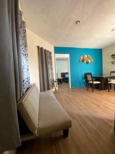 a living room with a chair and a blue wall at La Rivera 2 departamentos 