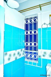 baño azul con ducha de azulejos azules en The Mevrose Resort, en Kisii