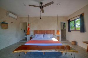 ein Schlafzimmer mit einem großen Bett und einem Deckenventilator in der Unterkunft Hotel Boutique Can Cocal El Cuyo in El Cuyo