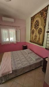 sypialnia z łóżkiem i obrazem na ścianie w obiekcie Home & Gardens 2-Bed Villa in Sevasti Katerini w mieście Kateríni
