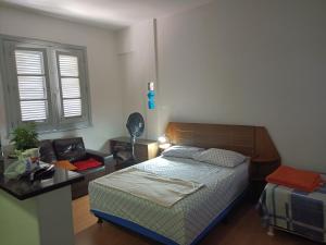 um quarto com uma cama, uma secretária e uma janela em Apartamento Centro Belo Horizonte em Belo Horizonte