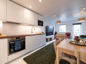 eine Küche und ein Esszimmer mit einem Tisch und einem TV in der Unterkunft Luxury Haven with King Suites and Parking in London