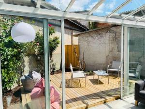 un giardino d'inverno con terrazza in legno e porte in vetro di Maison centre ville confortable a Marmande