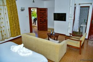 sala de estar con sofá y silla en The Mevrose Resort, en Kisii
